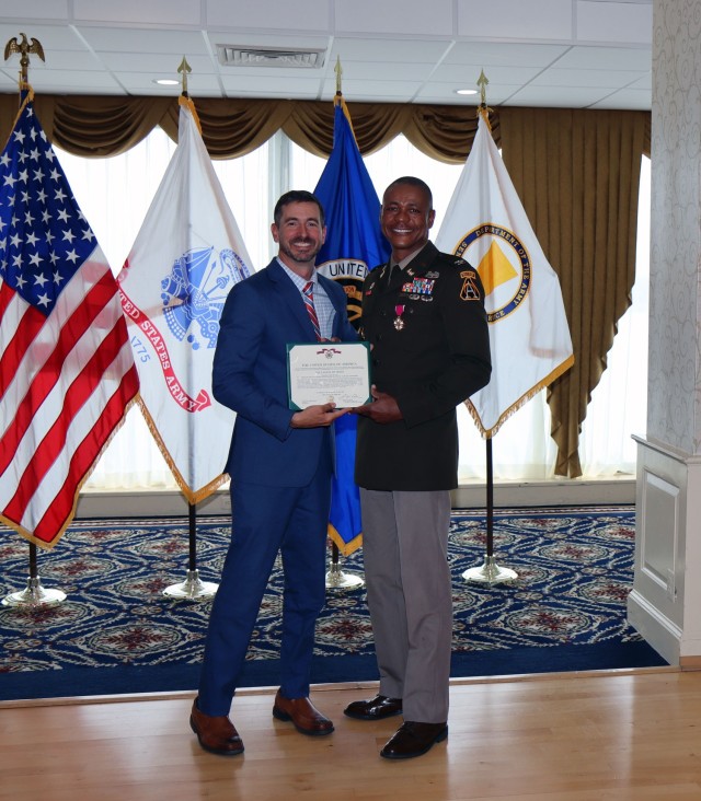 Mark Kitz, Program Executive Officer for Intelligence, Electronic Warfare & Sensors, presents the Legion of Merit to Col. Loyd Beal III for his accomplishments as the Project Manager for Terrestrial Sensors. (Photo Credit: Brian Cooper)