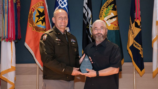 Brig. Gen. Ed Barker, Program Executive Officer for Intelligence, Electronic Warfare and Sensors, left, presents a C5ISR Hall of Fame award to Drew D'Angelo, son of late inductee Andrew R. D'Angelo, former PEO for Intelligence and Electronic Warfare. (Photo Credit: Sean Kief, CECOM Public Affairs)