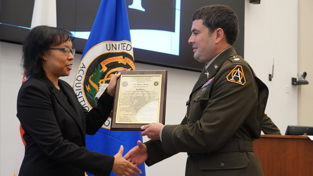 Lareina Adams, Project Manager, Terrestrial Sensors, presents the Product Manager Biometrics charter to Lt. Col. Paul Janker. (Jorge Parrado)