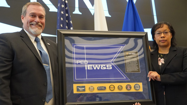 Outgoing Product Manager, Biometrics Forrest Church receives a plaque of appreciation from Lareina Adams, Project Manager, Terrestrial Sensors. (Jorge Parrado)