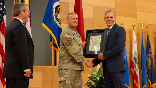 Chris Jais, incoming PM PNT project manager, accepts the organizations charter from Brig. Gen. Ed Barker, PEO, during a change of charter ceremony on APG. (Photo Credit: PEO IEW&S)