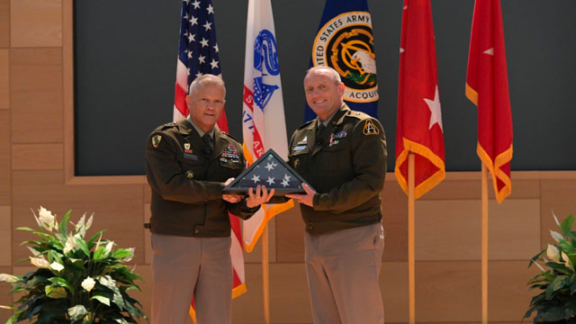 Brig. Gen. Ed Barker (right) receives an American flag from Lt. Gen. Robert Collins, Principal Military Deputy to the Assistant Secretary of the Army (Acquisition, Logistics & Technology), during his retirement ceremony. (Photo Credit: Shawn Nesaw, PEO IEW&S Public Affairs)